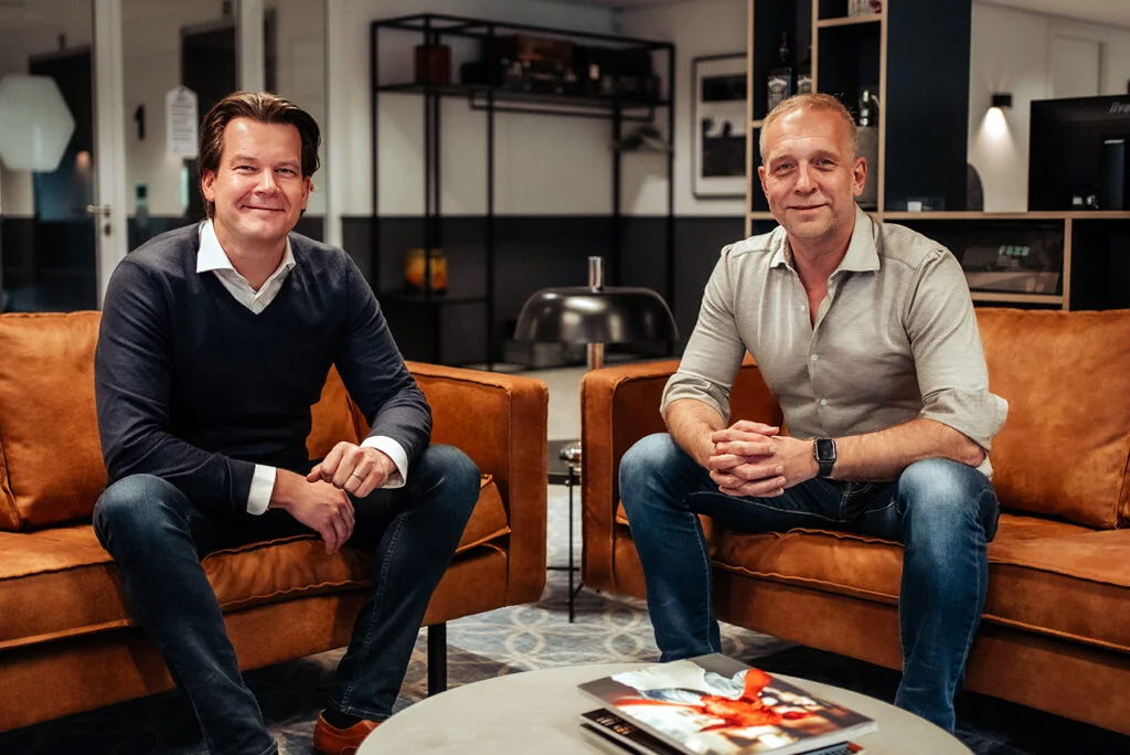 Two businessmen sitting together in a modern office lounge